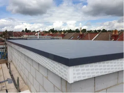 New flat roof with dark trim on a block-built extension