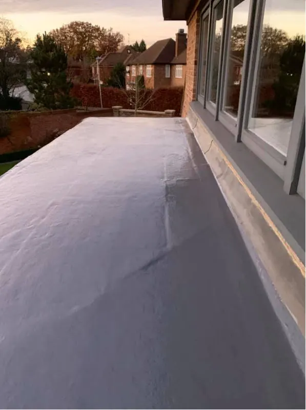 New grey GRP fibreglass flat roof running along the back of a house beside the windows